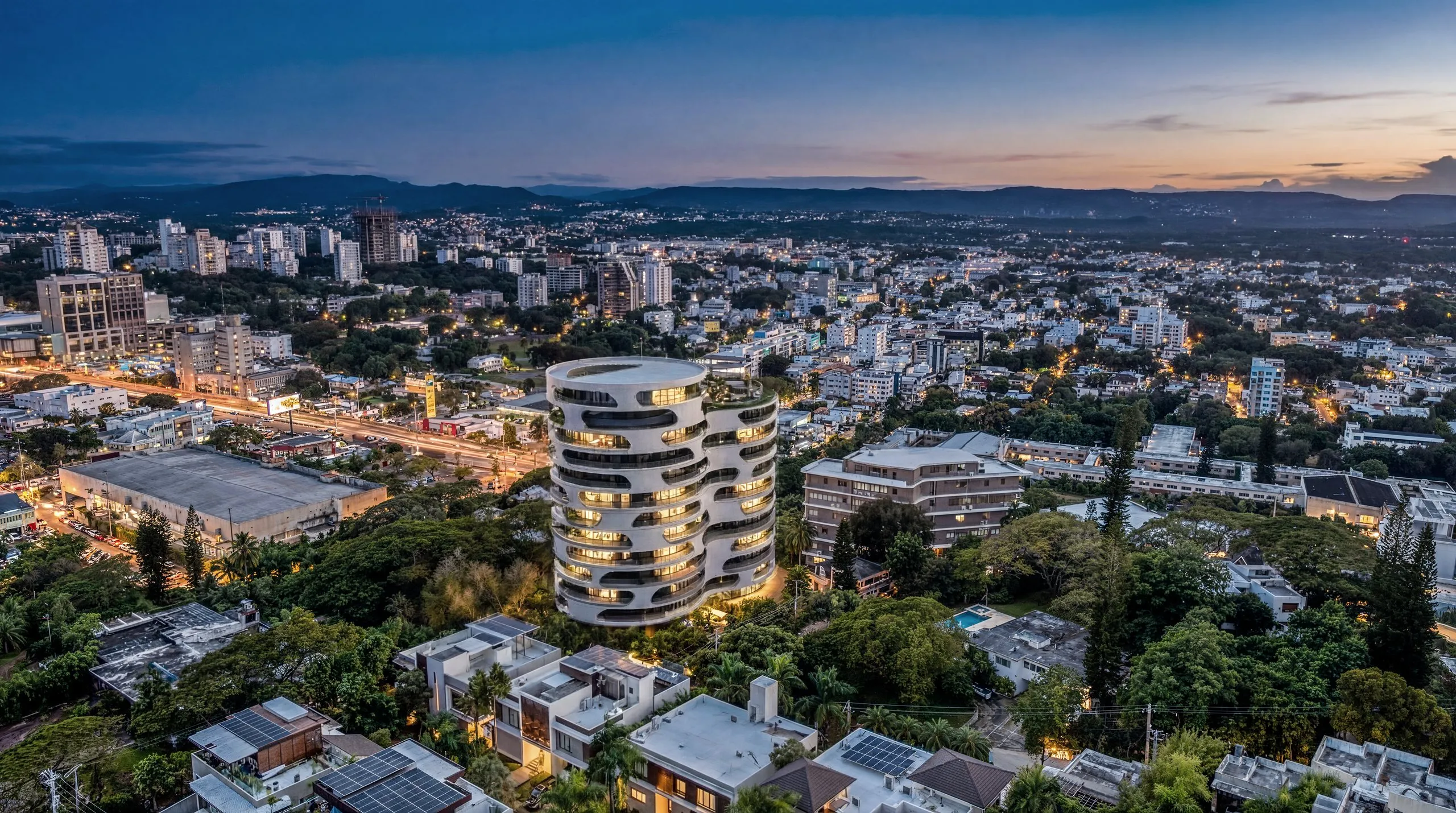 Legend al anochecer, rodeada de vegetación y con la ciudad de Santiago y la cordillera al fondo